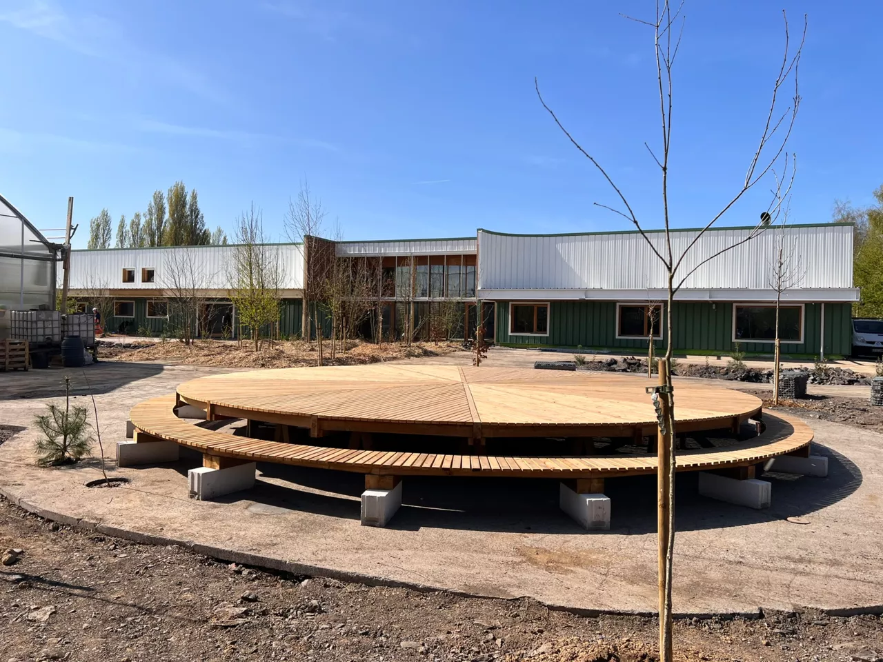 Vue du site démonstrateur de Noeux environnement avec sa grande plateforme circulaire en bois et ses aménagements paysagers, un espace conçu pour valoriser l’éco-construction et les matériaux biosourcés.